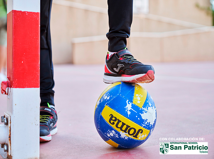 Niño calzando zapatillas escolares Boro de Joma mientras sujeta un balón.