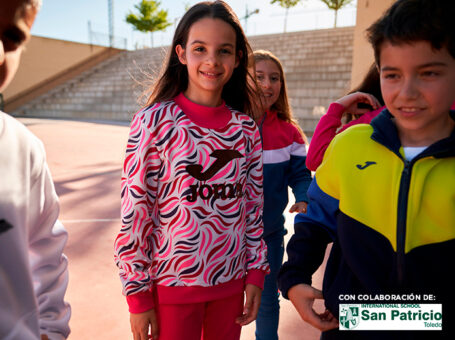 Niños y niñas vistiendo chándal escolar de Joma en el patio del colegio.