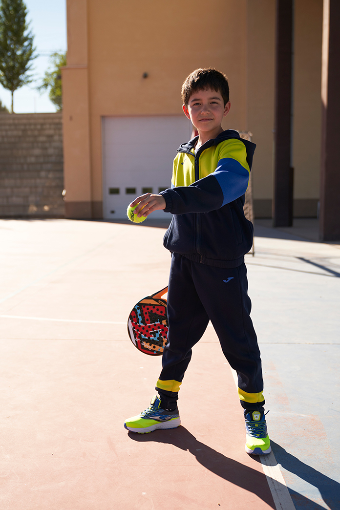 Menino com um fato de treino Part da Joma no recreio do colégio.