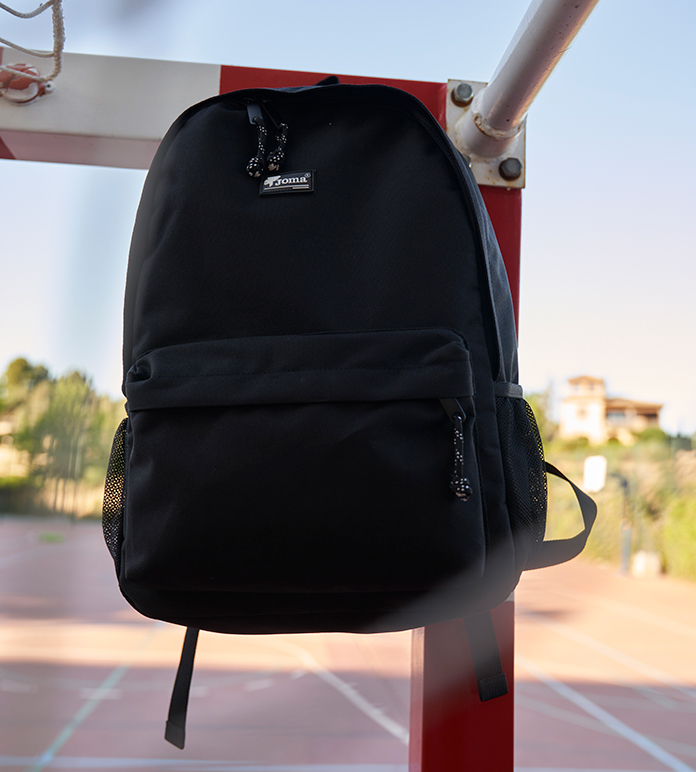 Joma school back-pack hanging on a goal.