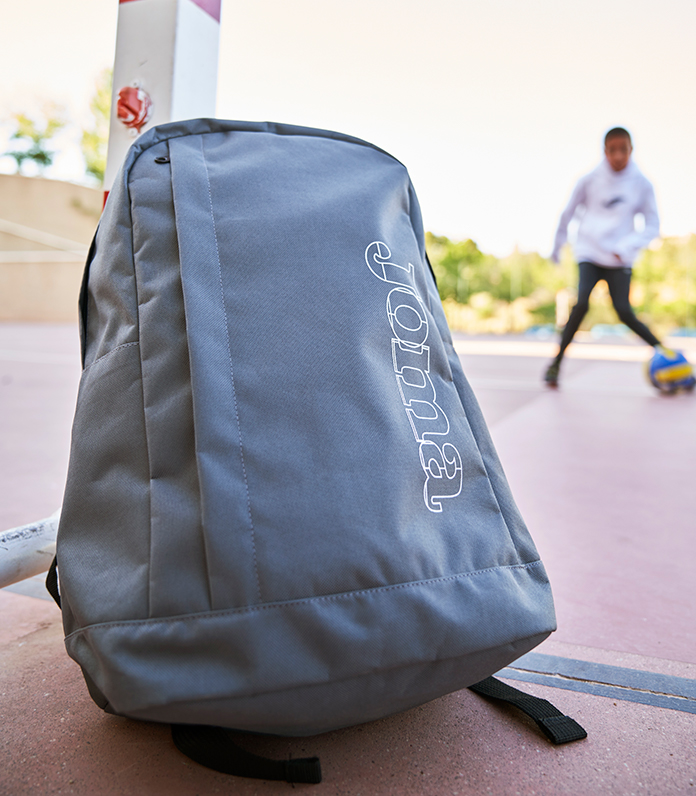 Sac à dos école Beta de Joma appuyé contre un but.