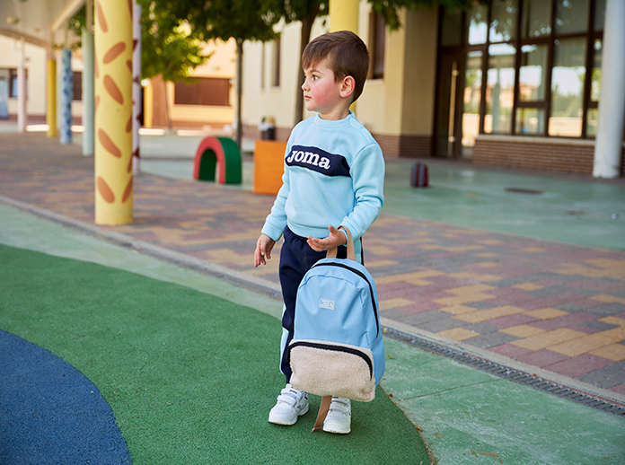 Chłopiec niosący torbę szkolną Joma Friendly.