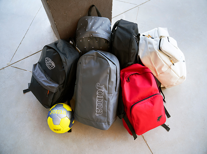 Mochilas escolares Joma encostadas a uma coluna no recreio da escola.